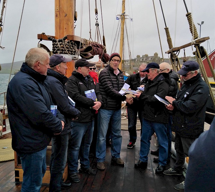 John Goodlad, Swan Trust Trustee and Author of The Cod Hunters, presents a copy of his book to the skipper of each of the 5 visiting Faroese Boats.