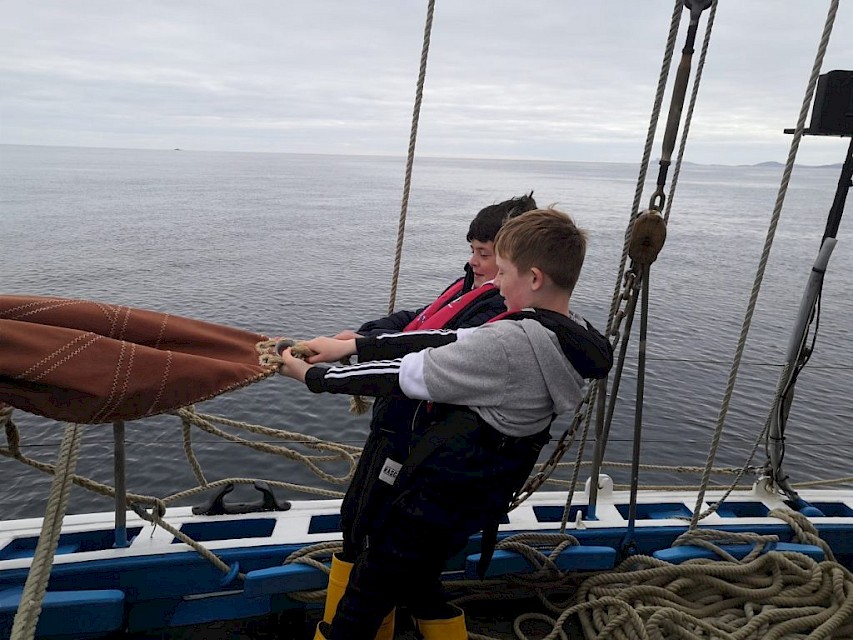 Pupils help stow away the jib