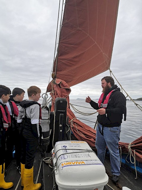 Skipper, Scott Sandison explains the dropping of the jib while briefing the pupils
