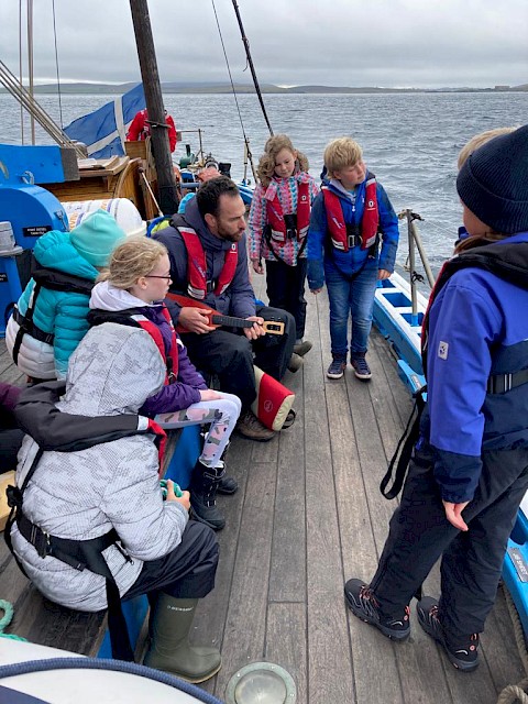 Primary 6 pupils enjoying sea shanties with student teacher Seth Travins