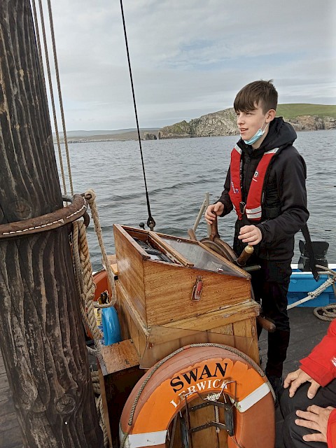 A secondary 3 pupil takes his turn at the helm