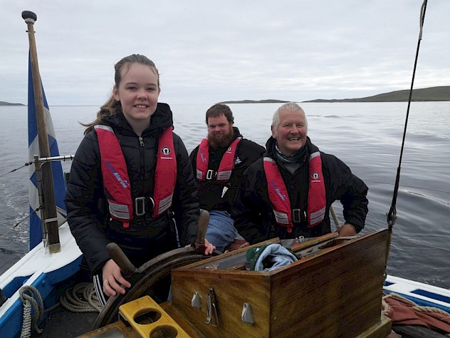 A Whalsay School pupil at the helm with Scott Sandison (pictured centre) who received a 2021 Spirit of the Community Award for his youth work aboard the Swan