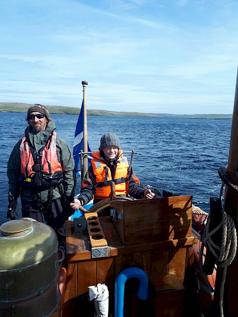 Schools pupil enjoying his turn at the helm of the Swan