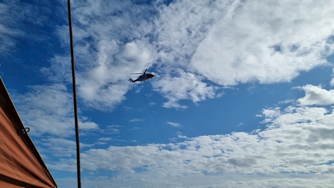 Coastguard helicopter circling and waving to Baltasound school pupils