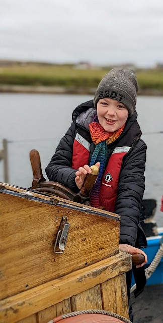 Burravoe School pupil enjoying their turn at the Helm of the Swan