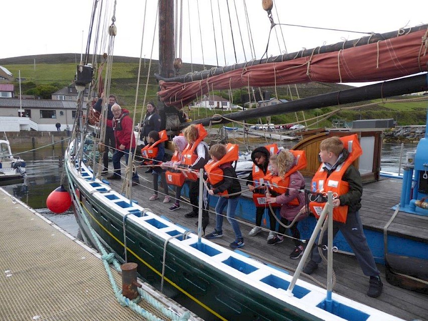 Children from the Scalloway Peerie Club about to hoist the foresail