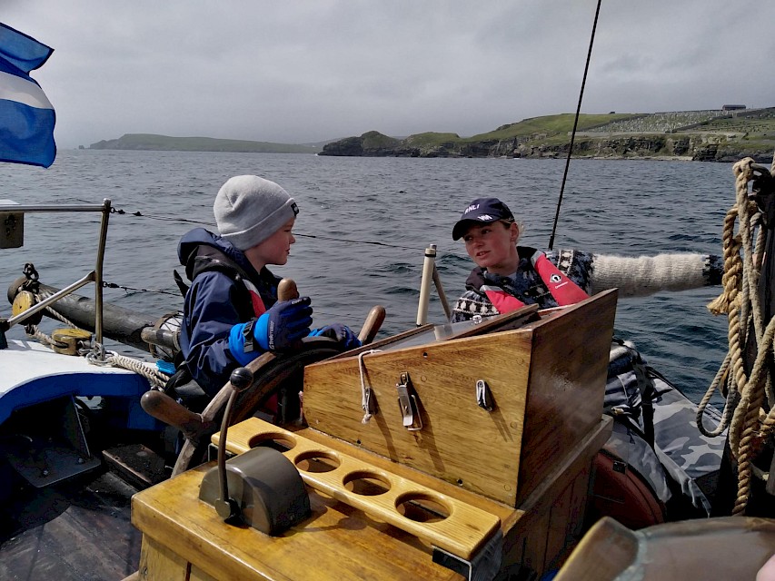 Family focused trip in Lerwick Harbour - Swan Skipper, Maggie Adamson with a young passenger at the helm.