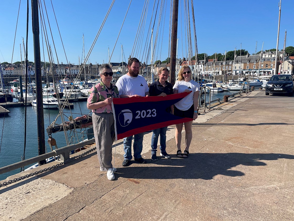 Scottish Fisheries Museum Chair of Trustees Jane Ryder presenting the National Historic Ships UK Flagship of the Year 2023 pennant to Swan Crew - Mate, Scott Sandison; Skipper, Maggie Adamson; and Bosun, Anja Kurtz